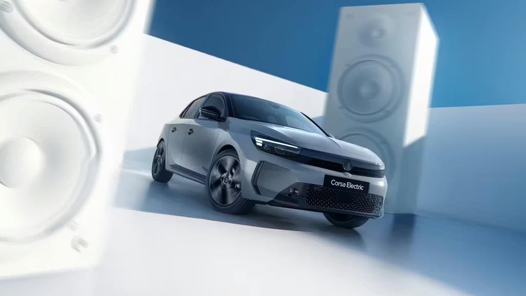 Vauxhall Corsa Electric showcased in a studio setting with oversized speaker installations.