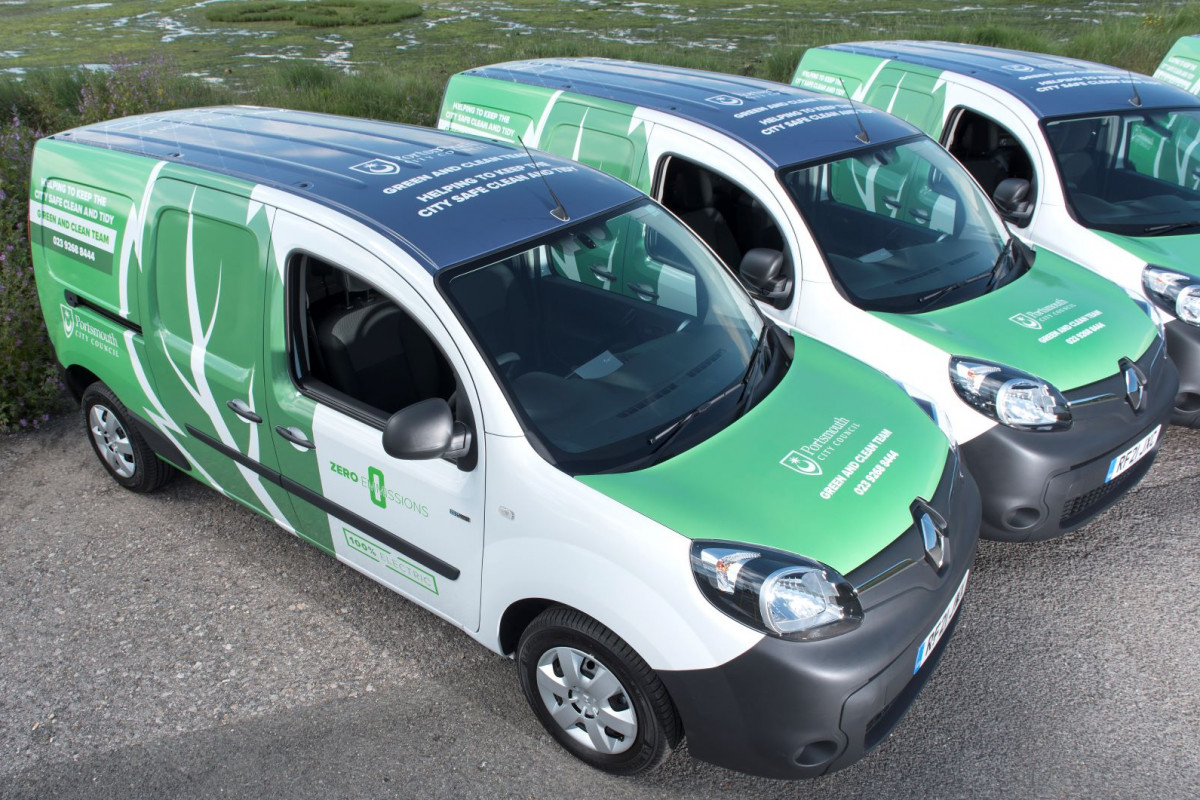 Green vans parked up next to eachother.