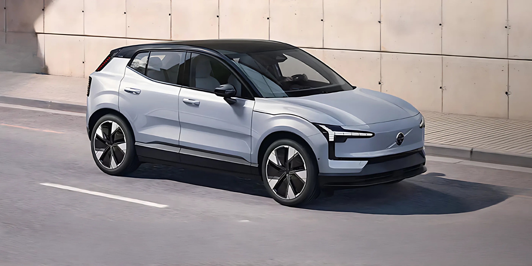 Volvo vehicle in light blue exterior displayed in a modern studio backdrop.