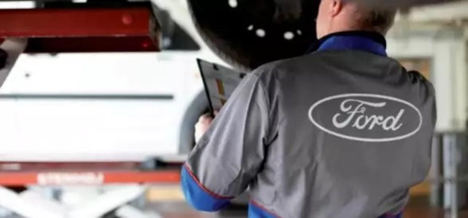 Ford mechanic assessing car 