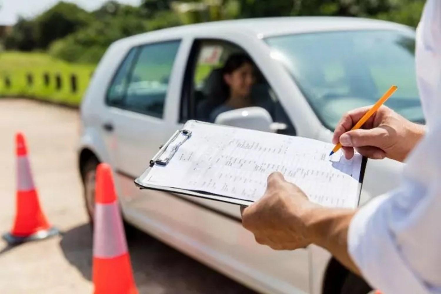 Driving instructor with clipboard assessing student 