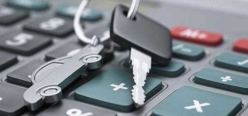 a key with a car-shaped keychain on top of a calculator