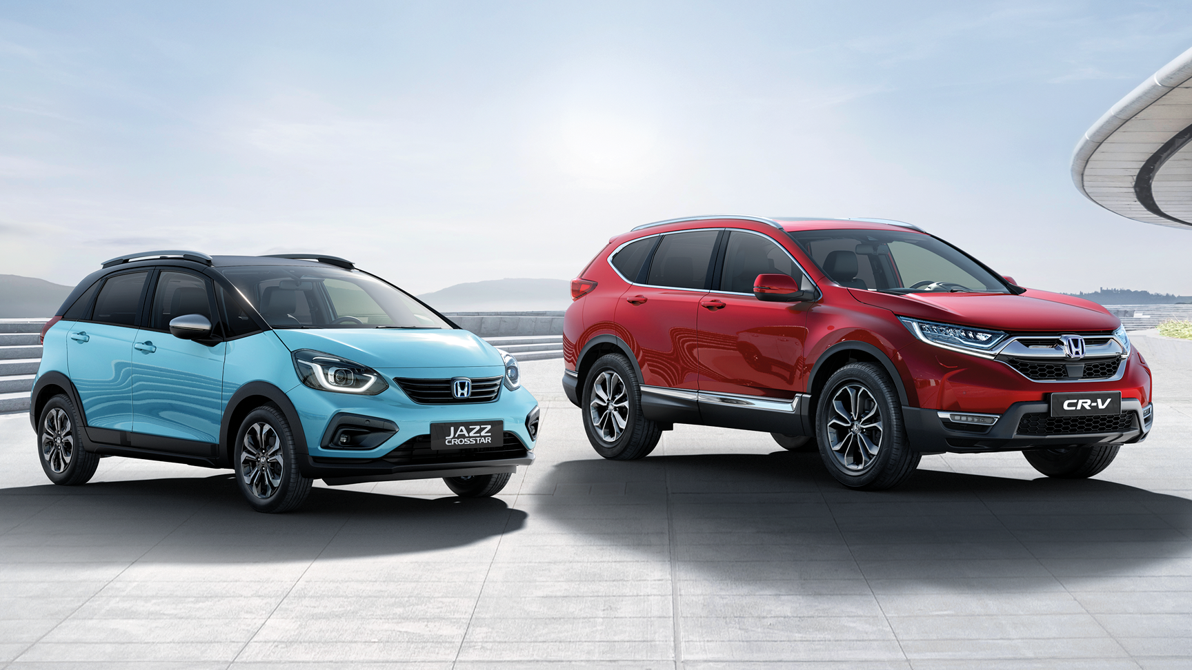 Blue Honda Jazz parked next to a red Honda CR-V
