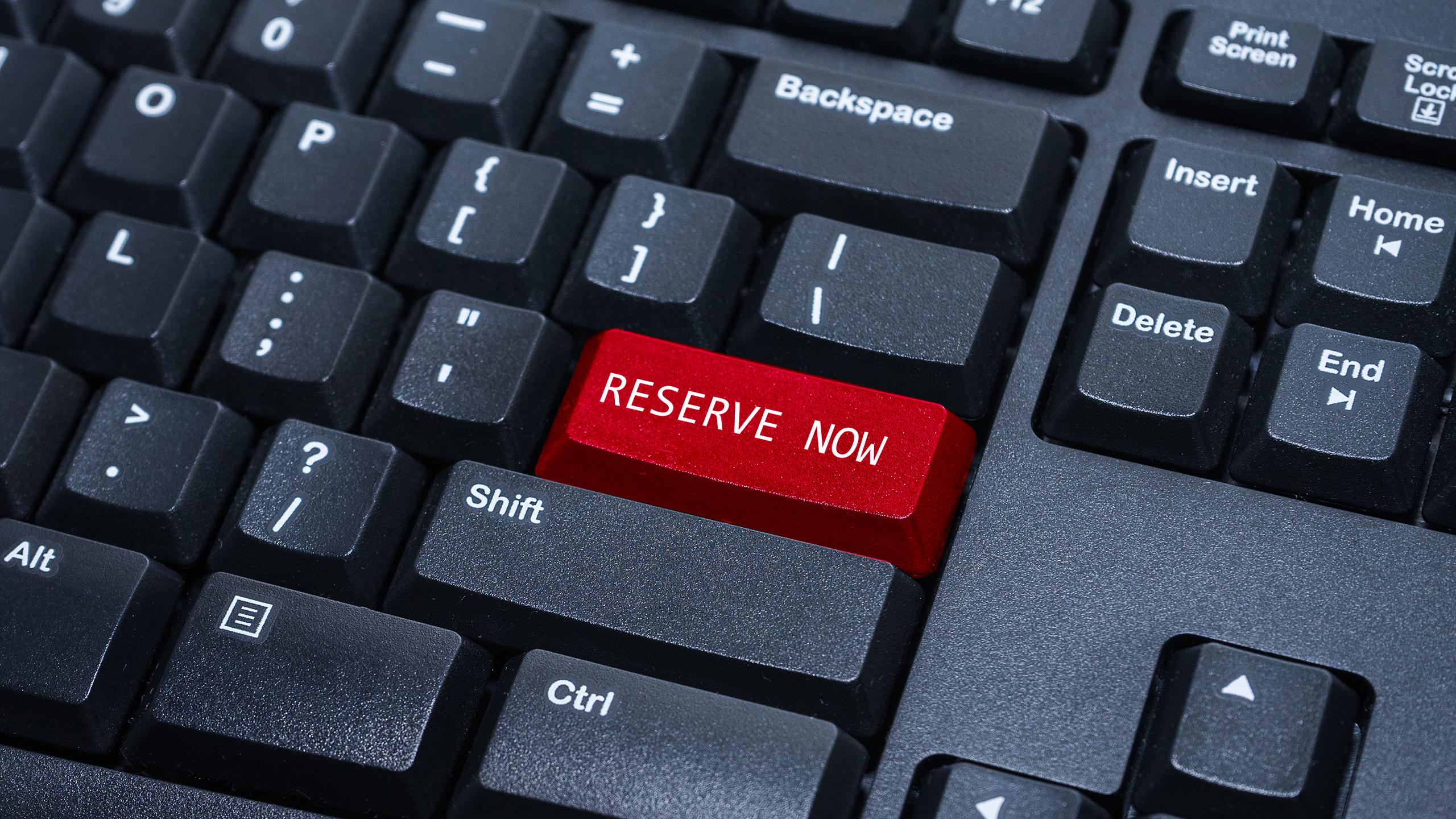 A keyboard with a red button saying "Reserve Now"