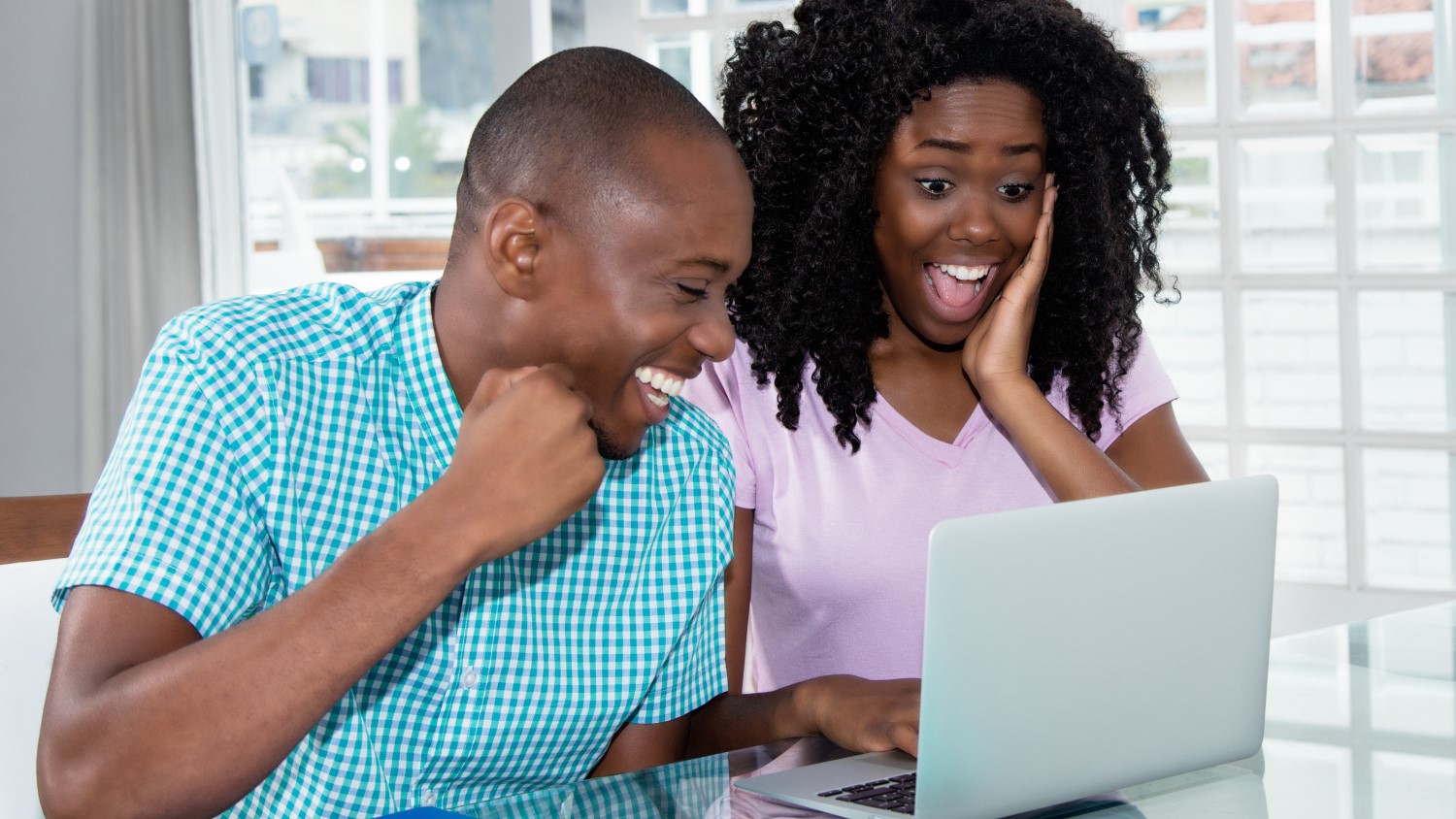 A couple looking to reserve a car online on a laptop