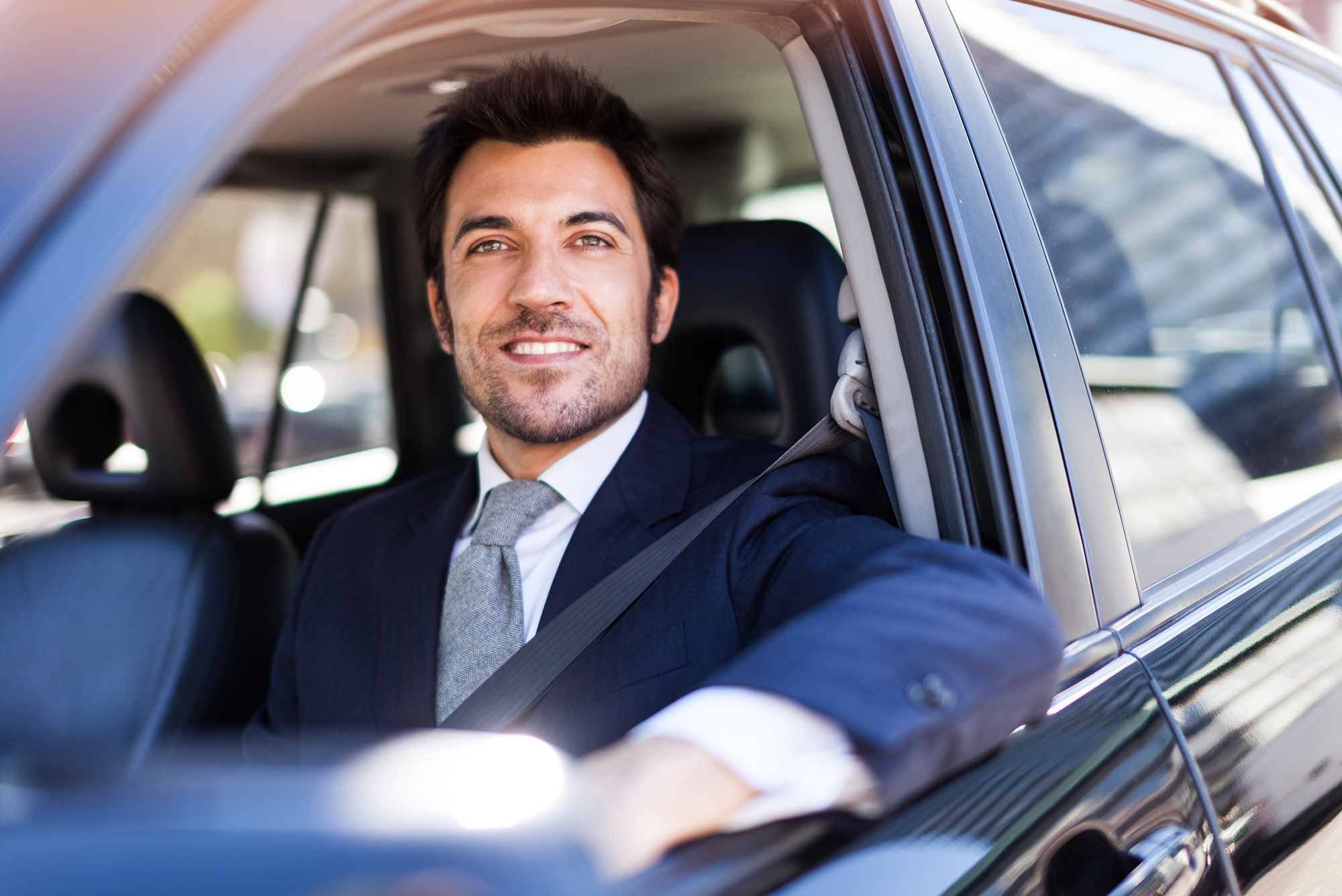 Nissan Business customers wearing a suit and sitting inside a new Nissan car