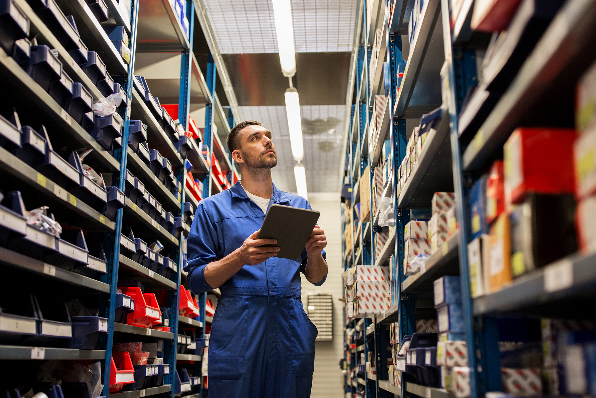 A mechanic checking Nissan car parts and accessories in a warehouse