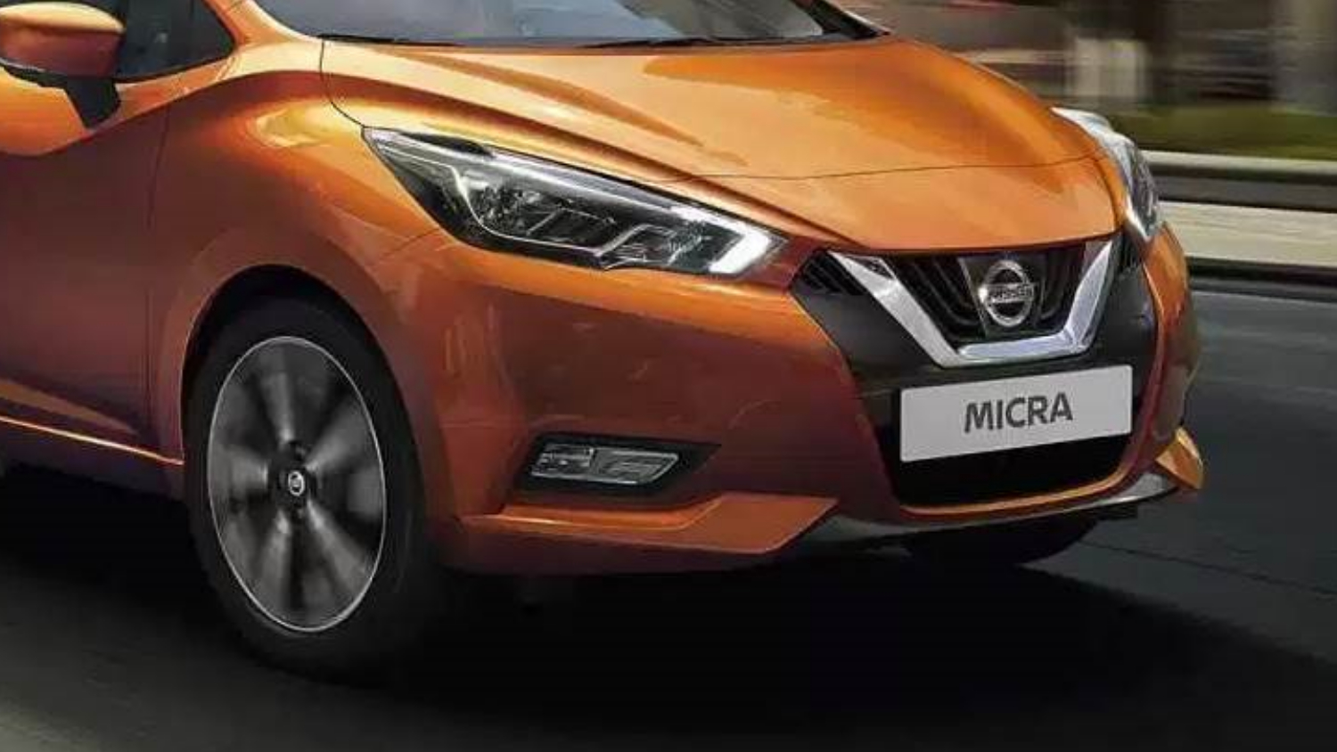 Front grille view of a Nissan Micra with a "Micra" number plate in motion