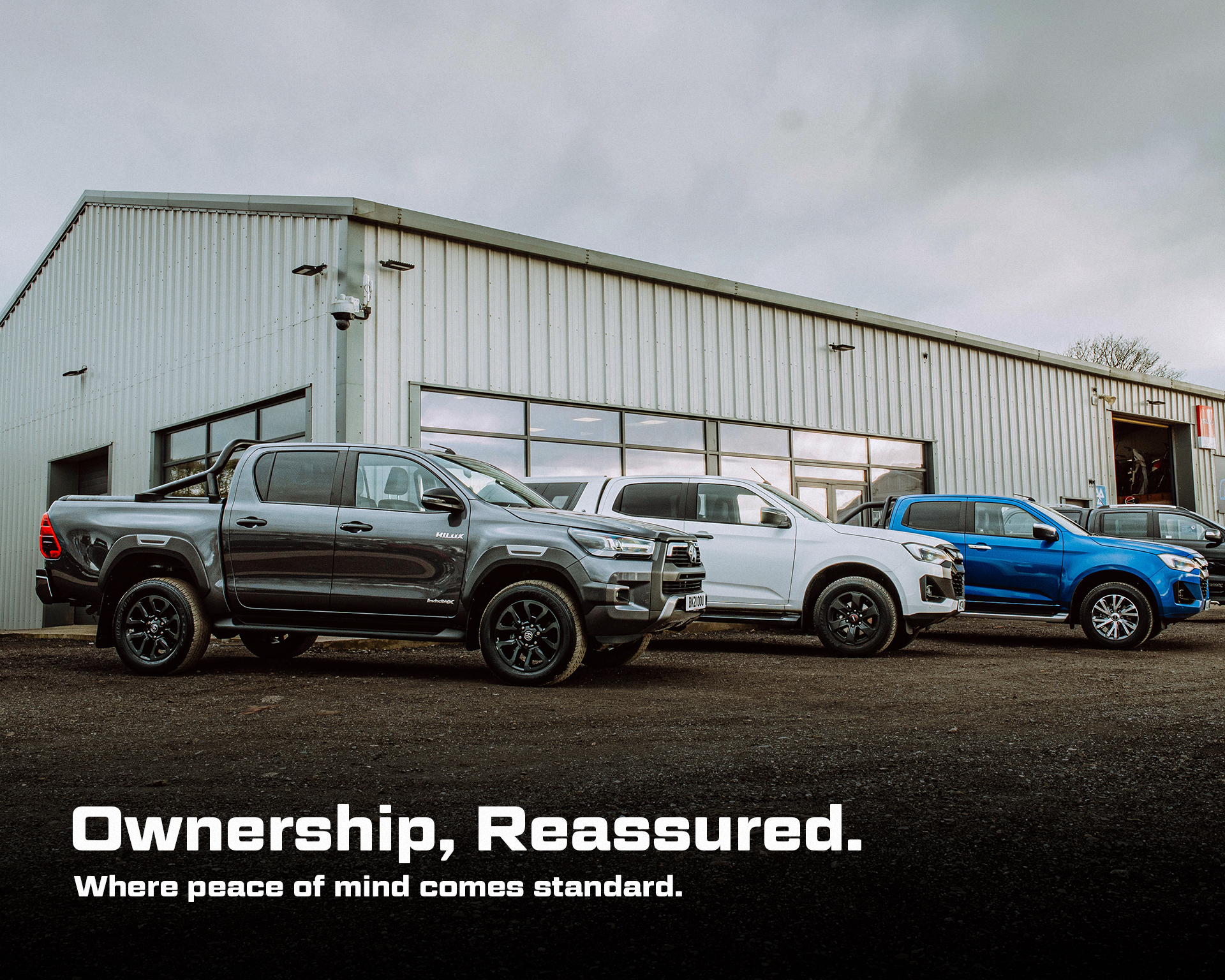 4x4s parked outside OVMS' Honiton dealership. Overlaid text reads "Ownership, Reassured. Where peace of mind comes standard"
