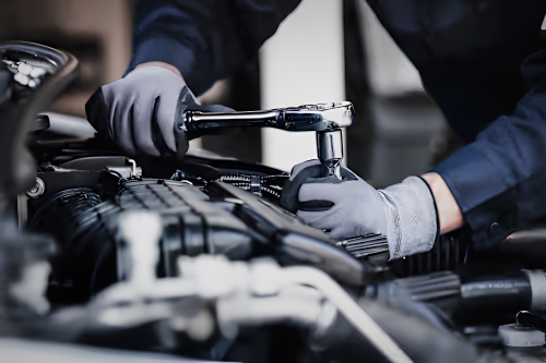 Technician carrying out routine vehicle maintenance in a workshop.
