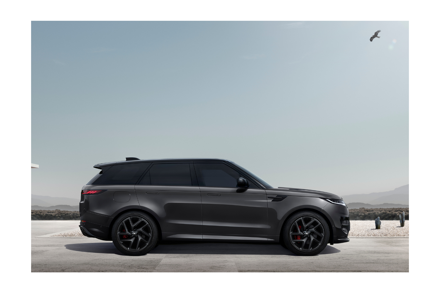 Black Range Rover Sport parked in desert landscape.