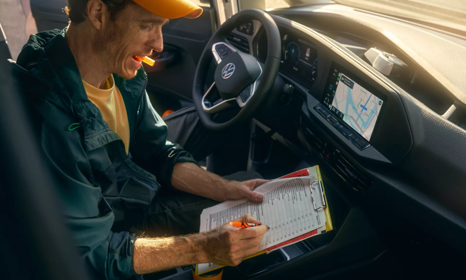Person sat in New Volkswagen Caddy Cargo Van with notepad