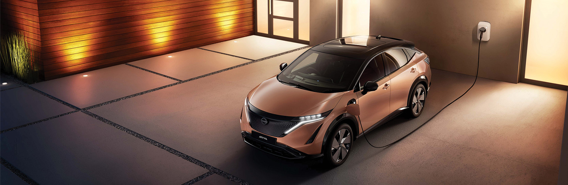 Nissan ARIYA parked up - electric charging outside a home