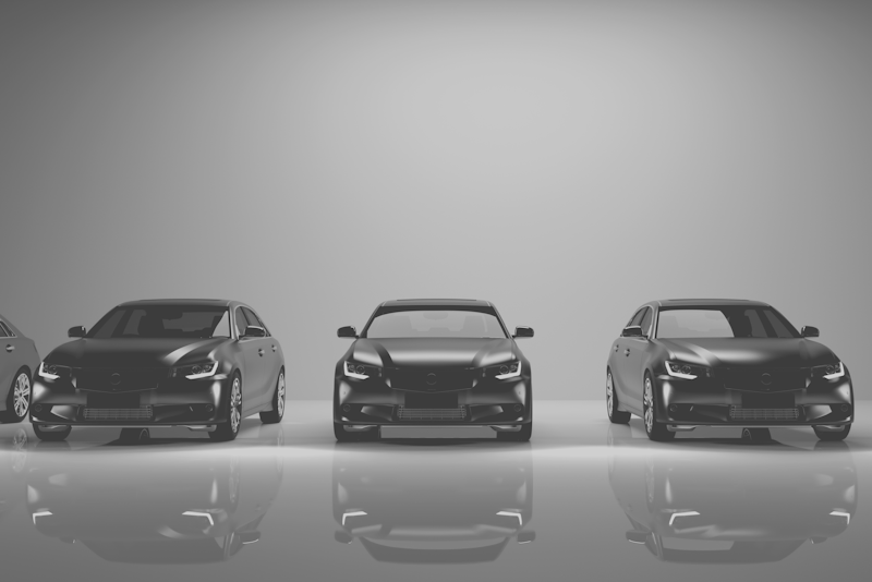 Black and white image of cars in a row.