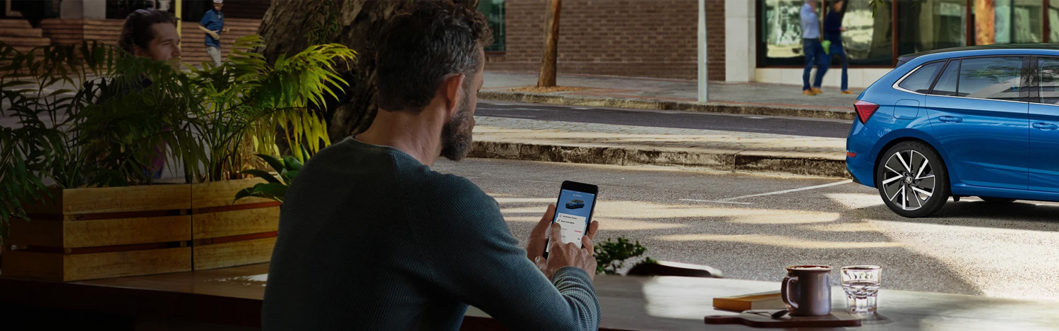 Person Sat On Phone On SKODA Connect App