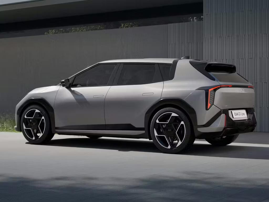 Rear three-quarter view of the Kia EV4 in metallic grey, featuring bold geometric alloy wheels, distinctive vertical LED rear lights and a striking crossover silhouette.