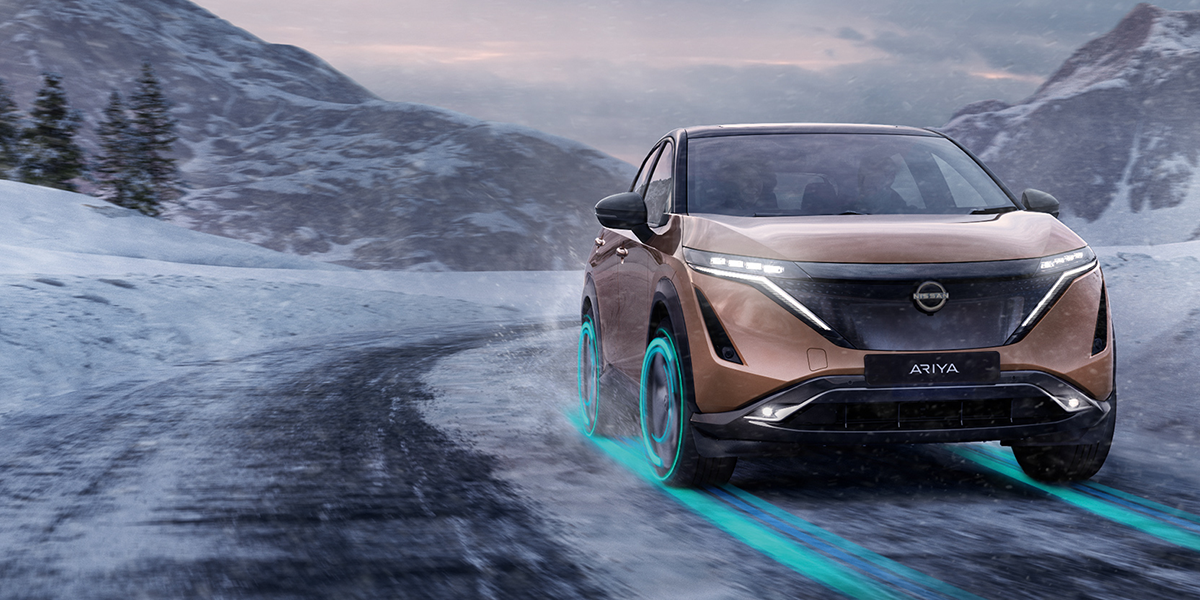 Bronze Nissan Ariya driving in snowy conditions 