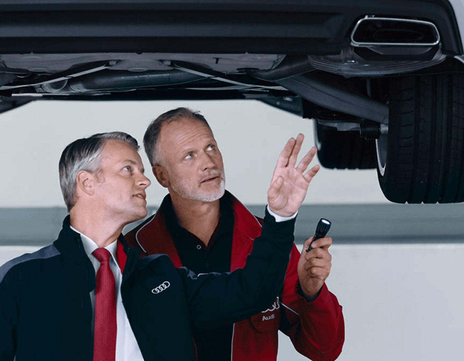 Audi Mechanics Inspecting Underneath Audi Vehicle