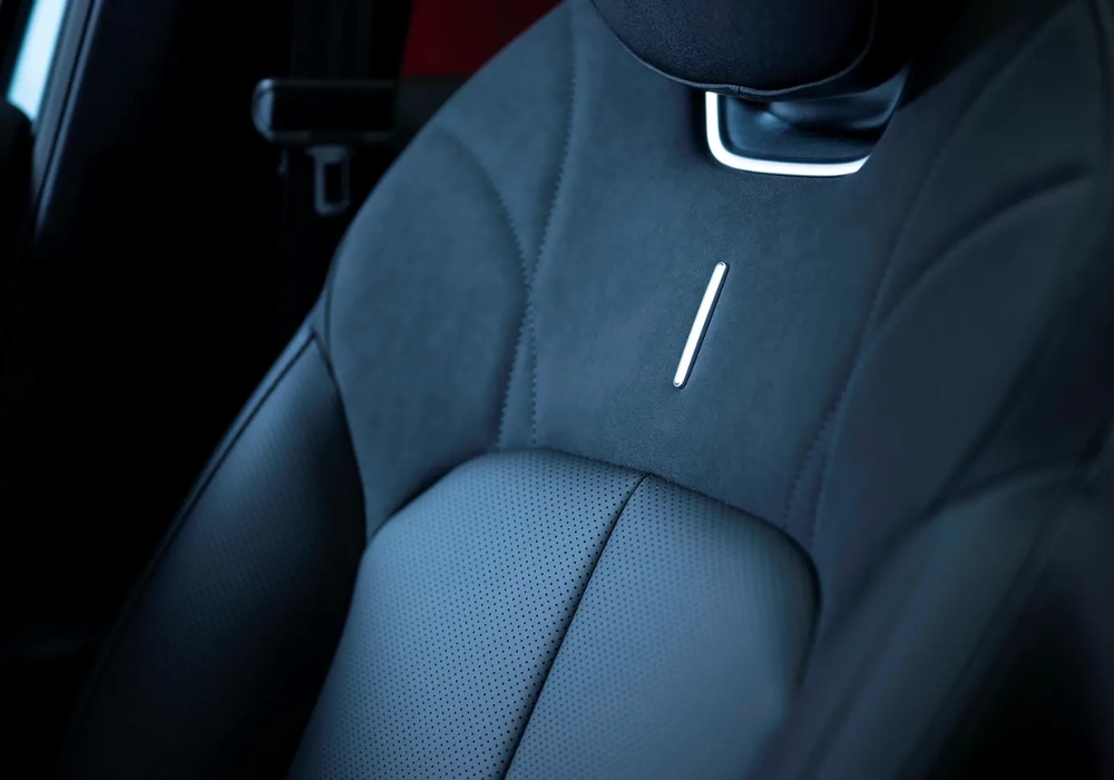 Close-up of OMODA seat upholstery showing perforated leather and stitching detail.