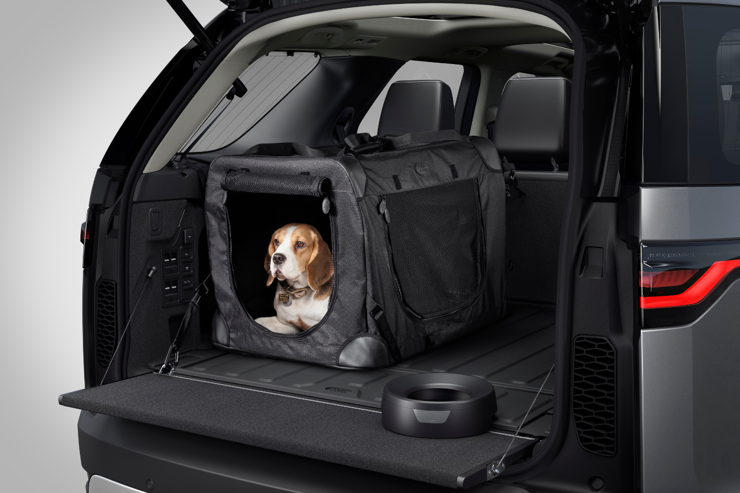 Land Rover Defender boot fitted with pet carrier and dog travel accessories.