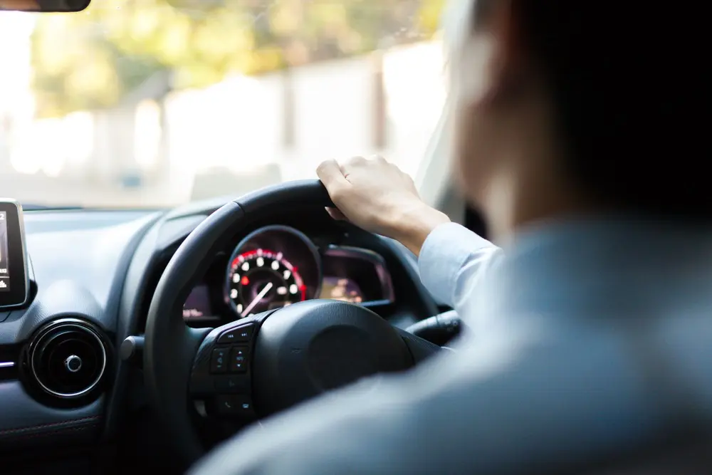 man driving steering wheel close up