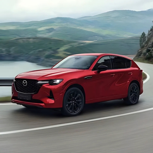 Mazda CX 60 in red driving in a mountain side road