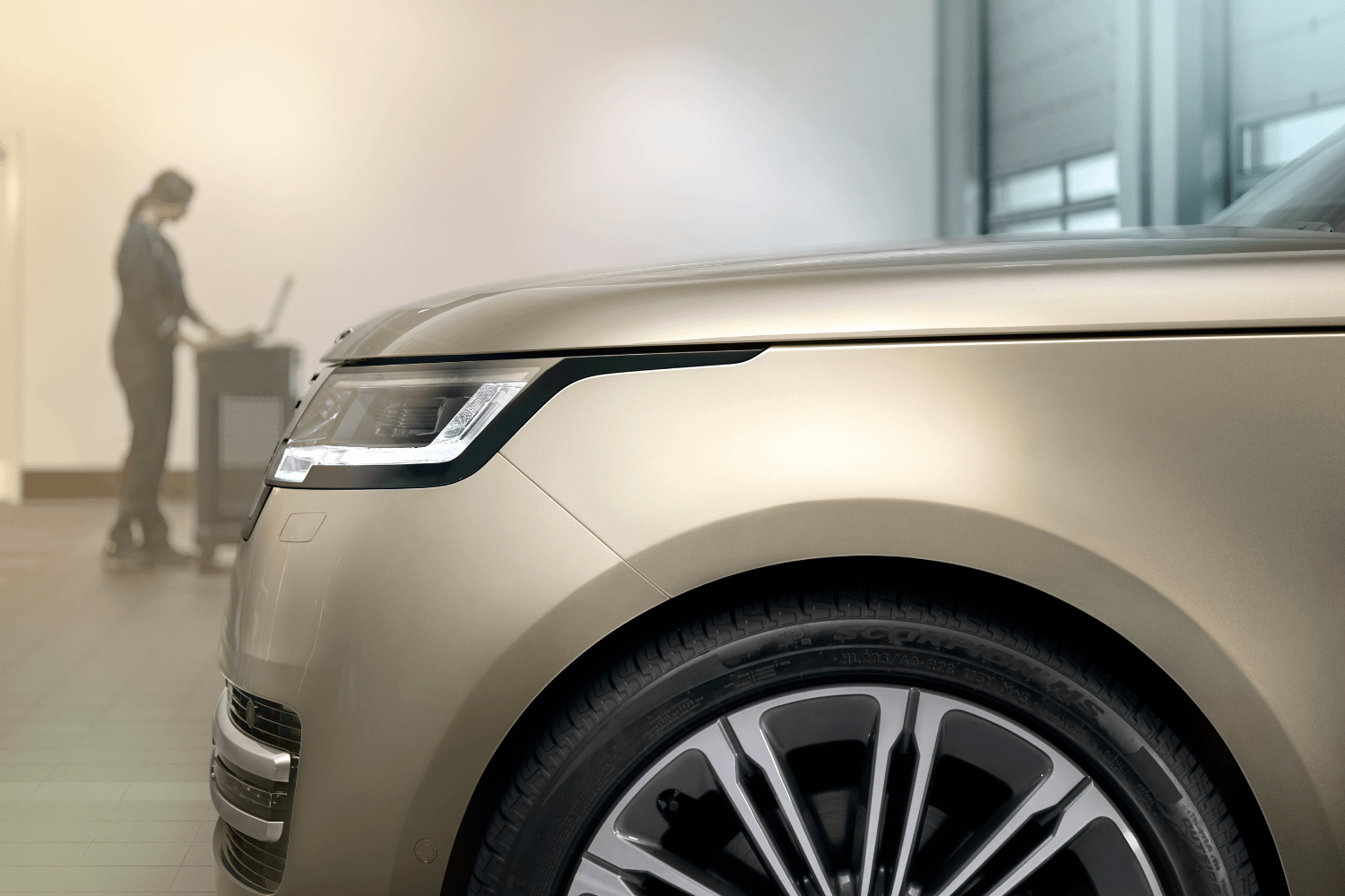 Front quarter view of latest-generation Range Rover in showroom setting.