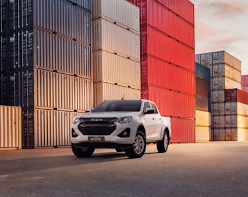 White Isuzu DL20 by shipping containers