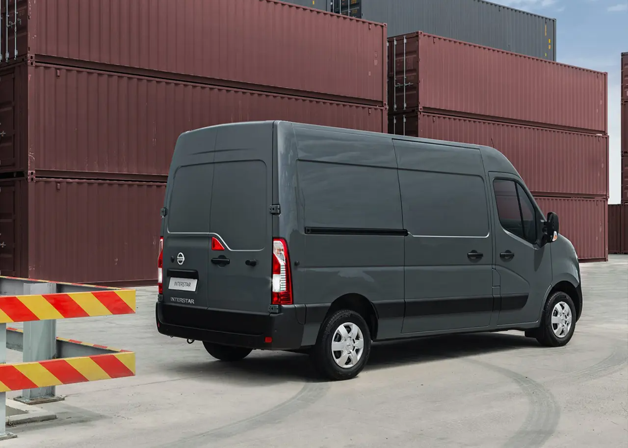 Rear side view of Nissan Interstar by shipping containers