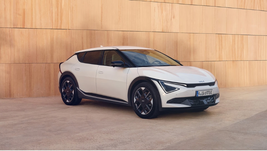 Kia EV6 in white parked in front of an urban-style wall.