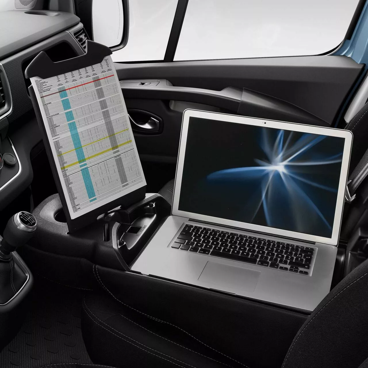 Centre console laptop area of Renault Trafic with a laptop positioned on the workspace surface.
