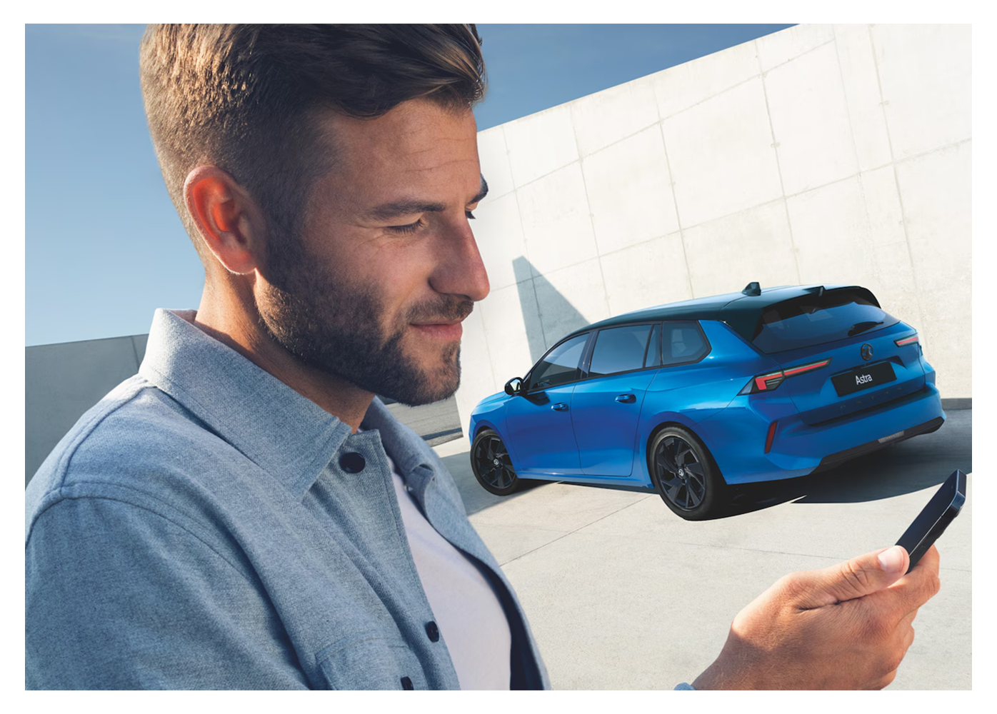 man on phone infront of a blue vauxhall astra