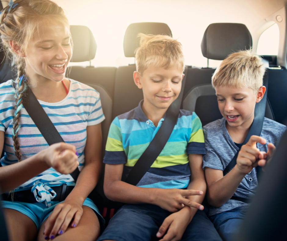 three children playing rock paper scissors in car on a roadtrip. kids are laughing and having fun