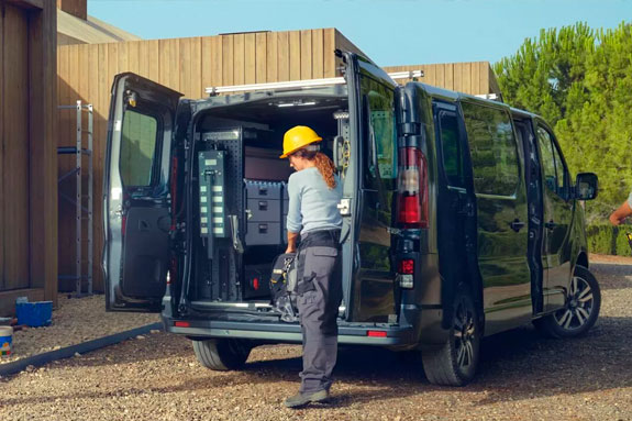 person in hard hat loading back of Renault Trafic