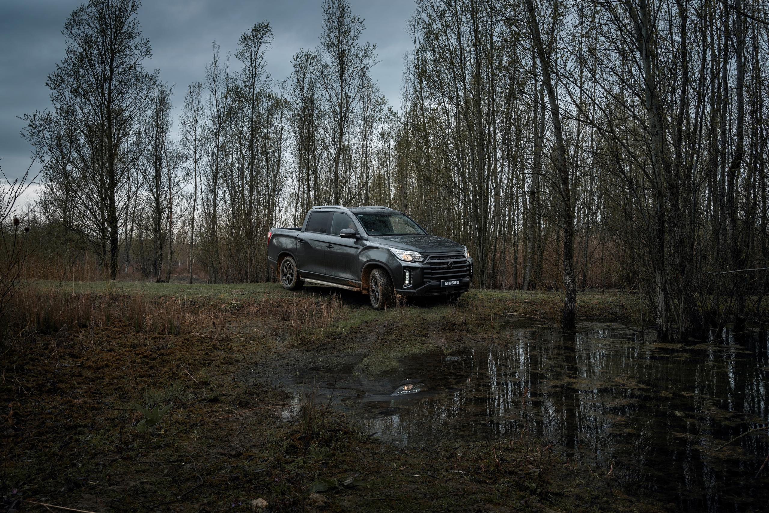 Grey SsangYong Musso in mud 