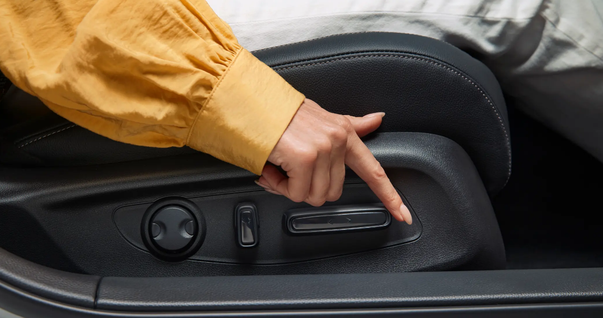A driver adjusting the seat within a Honda Civic