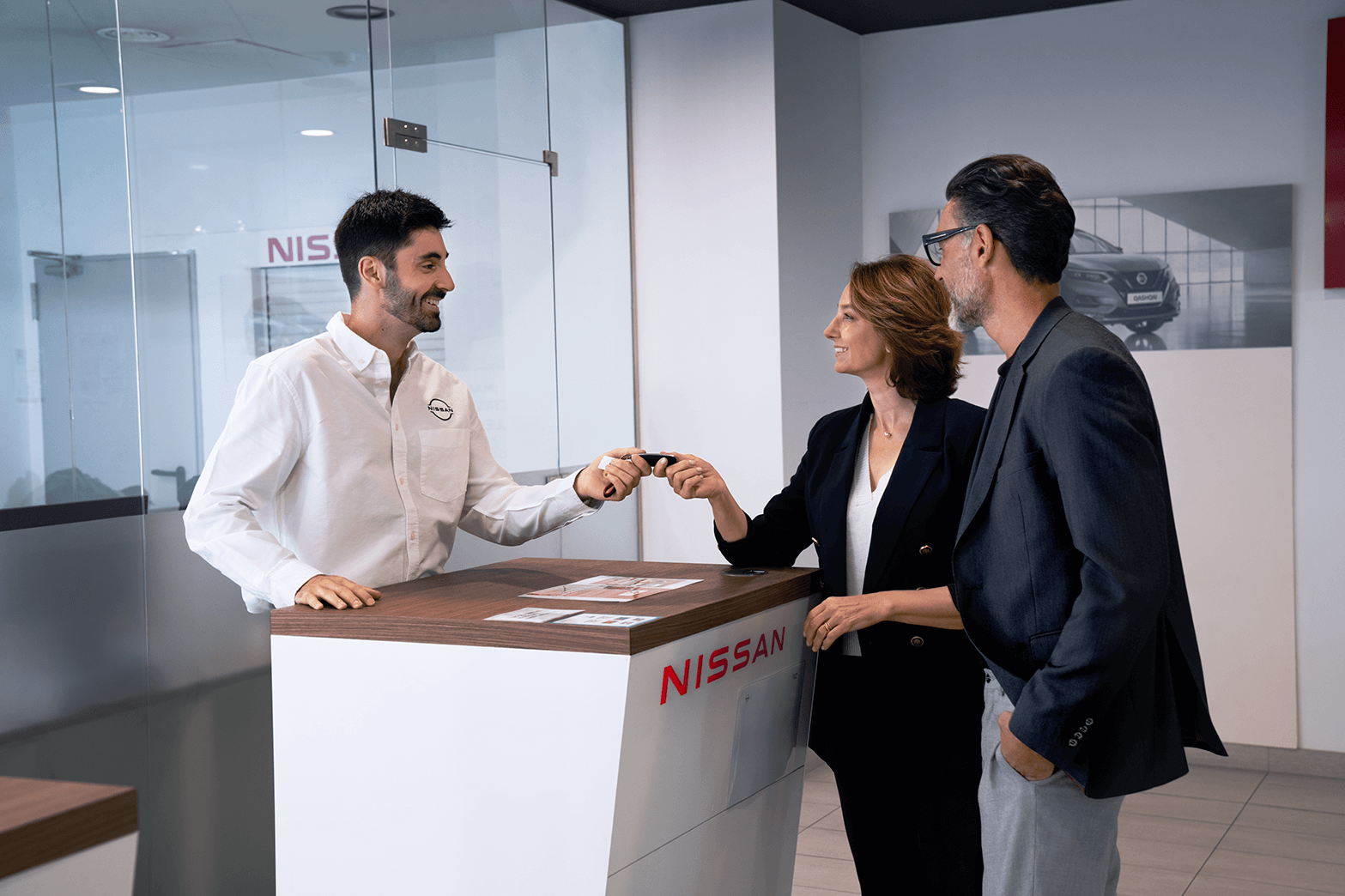 Customers and an employee inside a Nissan dealership