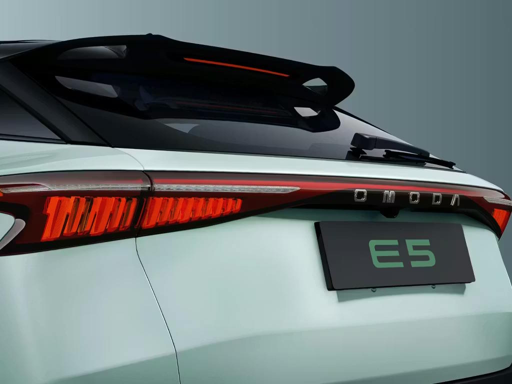 Rear close-up of the OMODA E5 electric SUV in mint green, featuring full-width LED tail lights, integrated rear spoiler and bold lettering across the tailgate