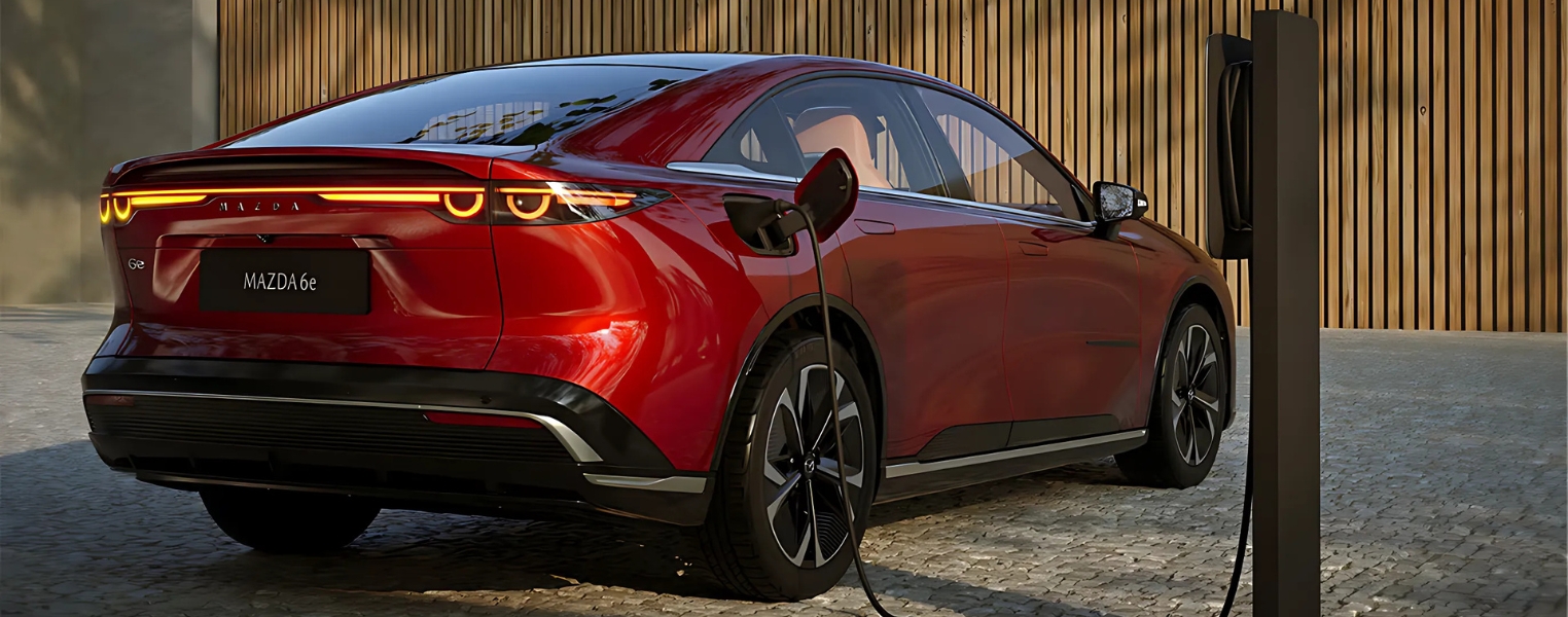 Mazda6e rear view shown charging at home.