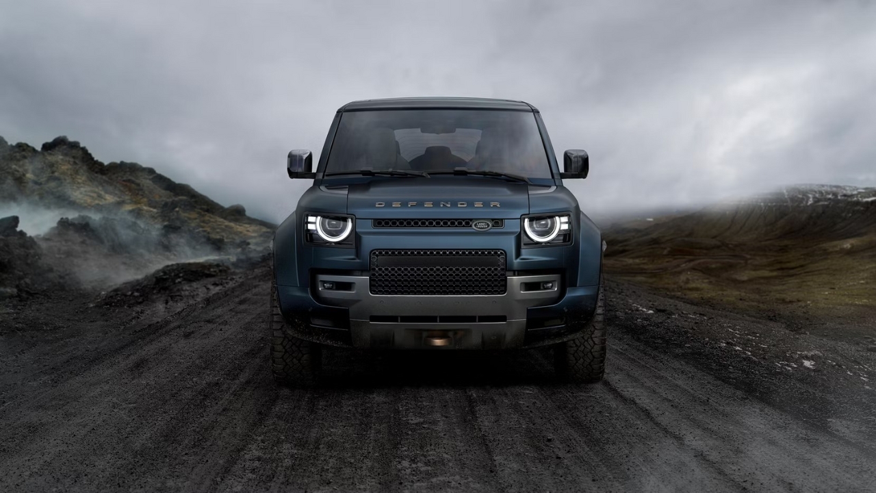 Front view of a Land Rover Defender OCTA driving along a rugged off-road trail.