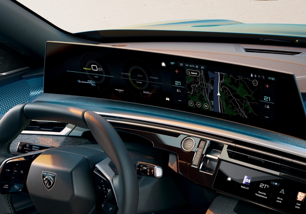 Interior of Peugeot E-3008 featuring wide curved digital display with navigation, climate controls, and driver information.