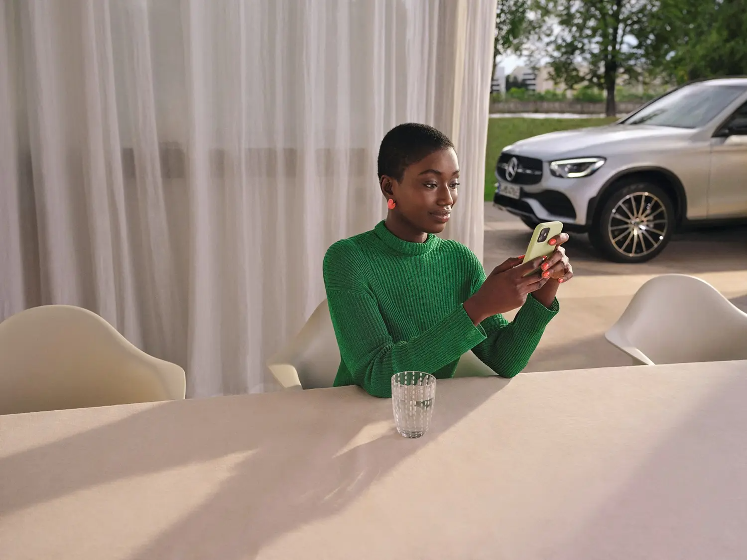 Person on Smartphone in front of Mercedes-Benz Vehicle