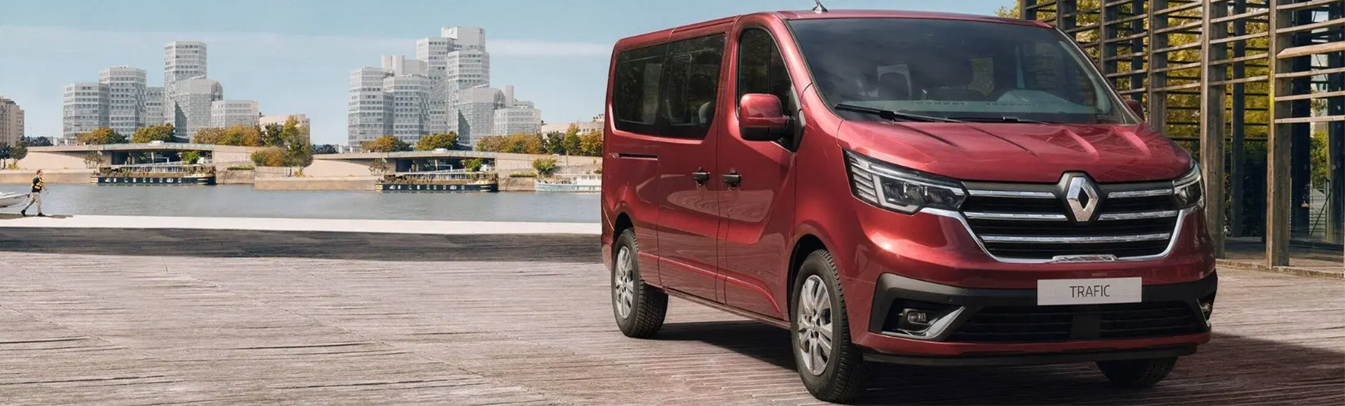 Red Renault Trafic Passenger parked by river front facing 