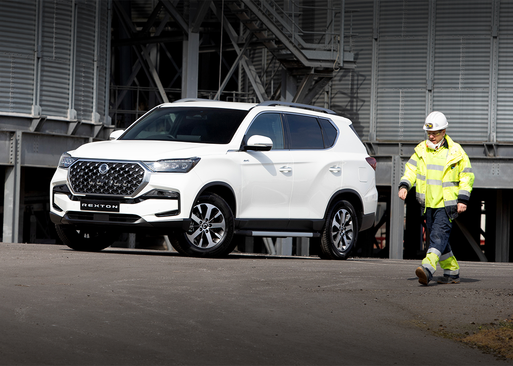working man walking aby a kgm rexton