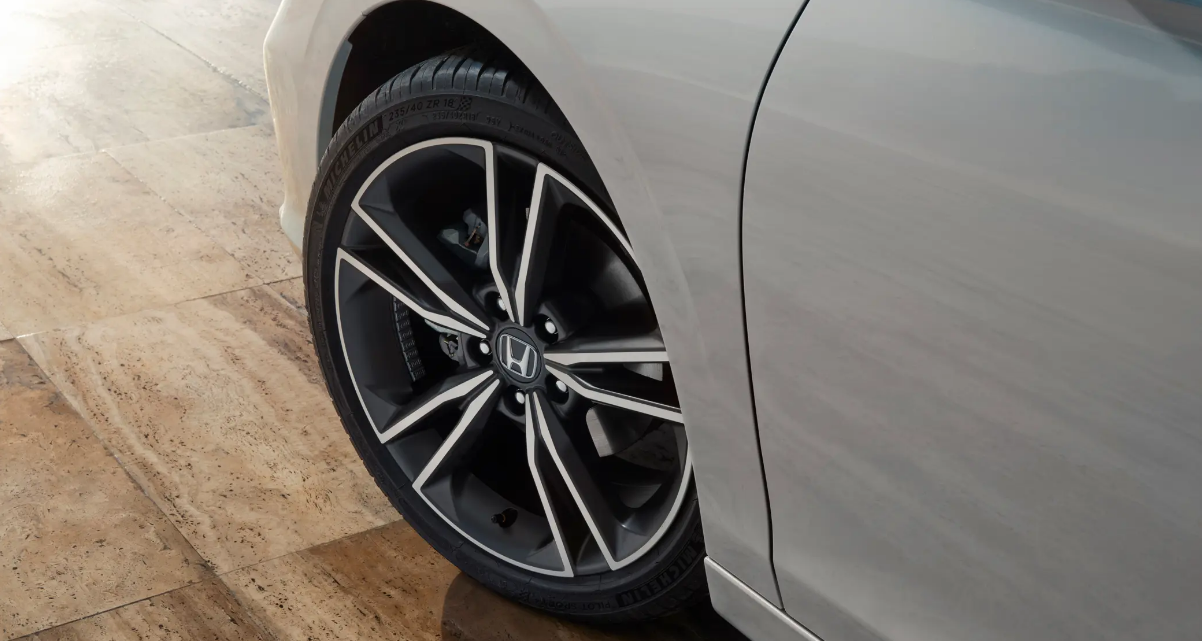 A front wheel on a white Honda Civic.