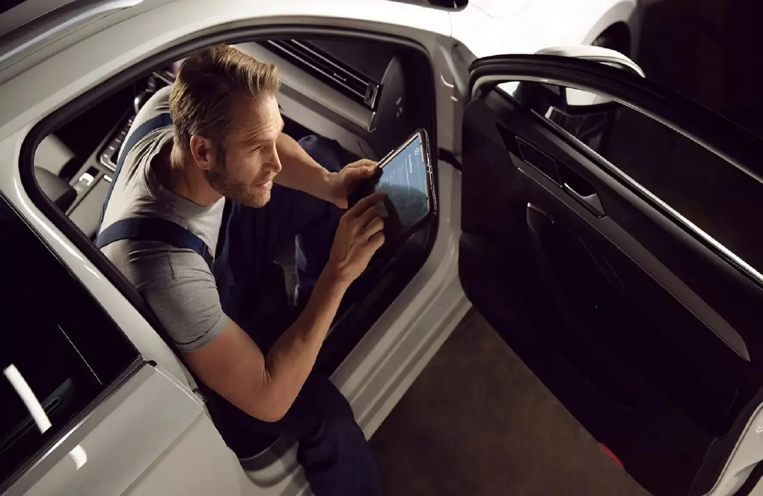 Volkswagen mechanic sat in vehicle on a tablet