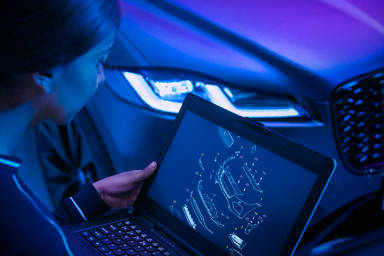 Person on Computer in front of Jaguar