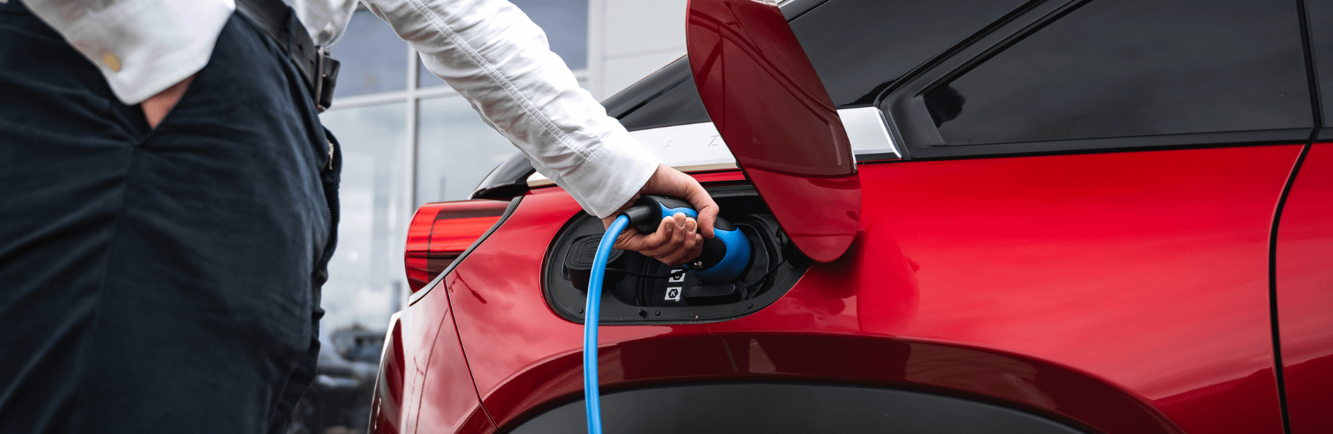 Mazda electric car being plugged in to charge.