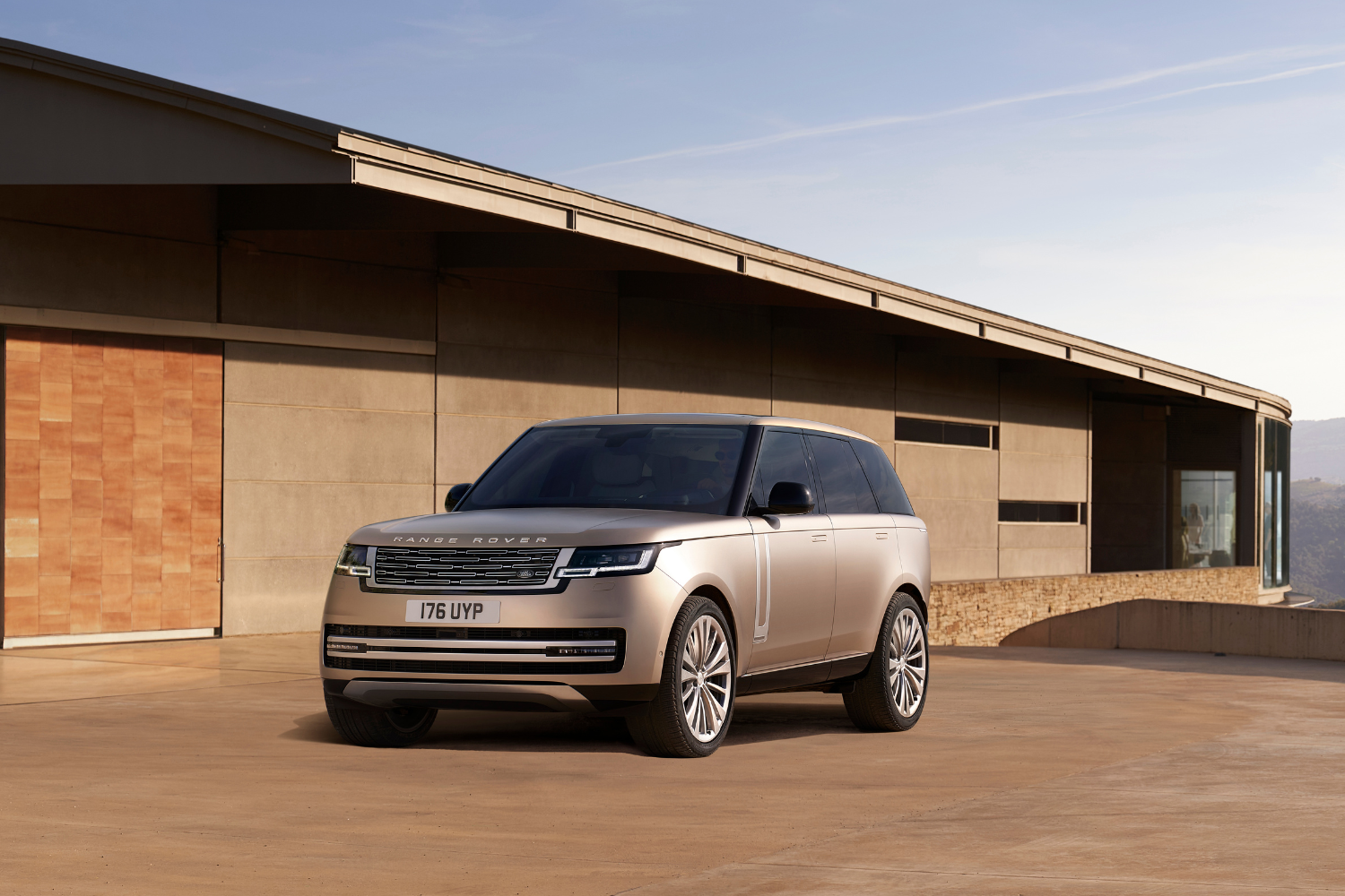 Range Rover SUV on terrace with modern architecture backdrop.