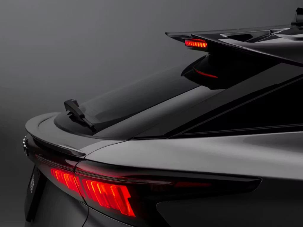 Rear detail view of the Omoda 5 SUV in black, showcasing the illuminated LED tail lights, integrated rear spoiler and sleek tailgate design with distinctive light signature.